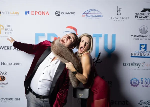 Two guests striking a playful pose at the step and repeat