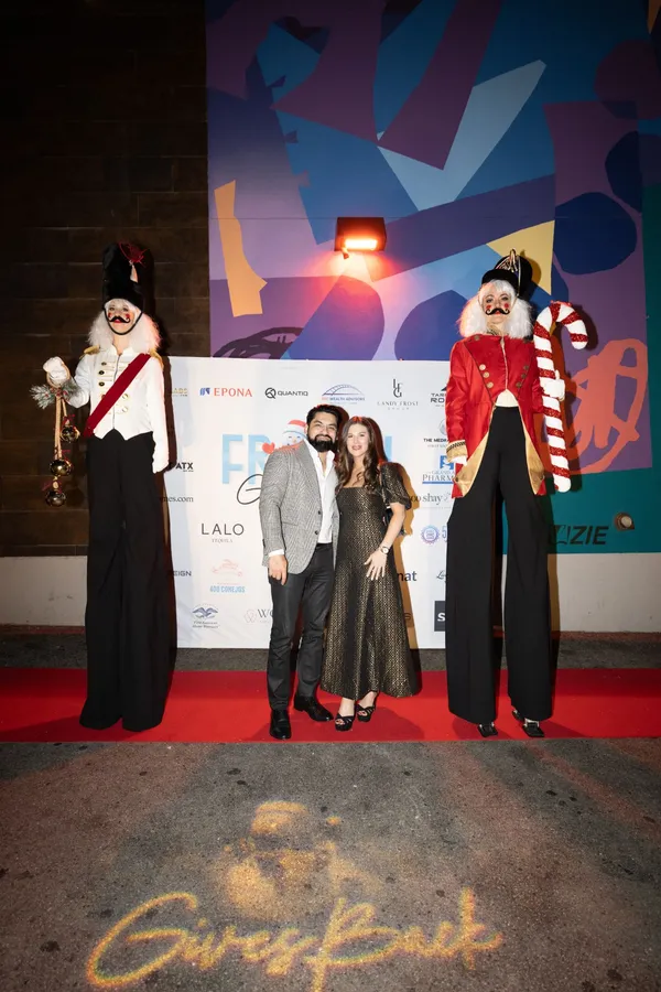 Guests on the red carpet flanked by nutcracker stilt walkers